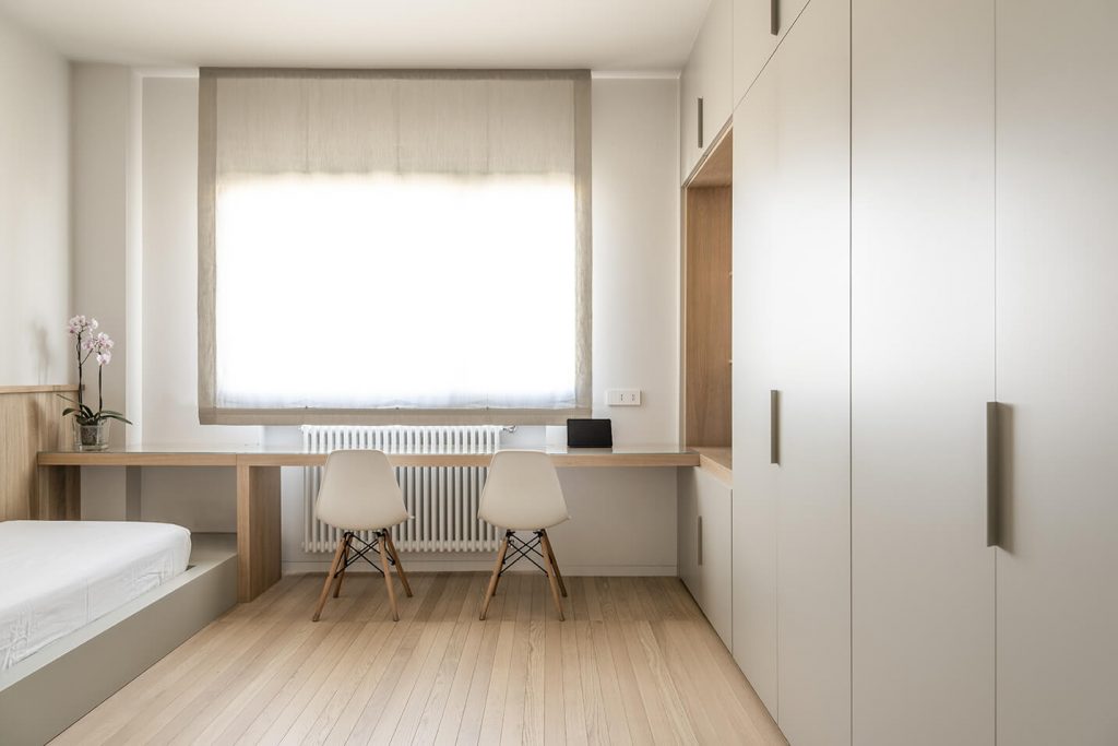 Dettaglio scrivania e armadi camera da letto grigio tenue